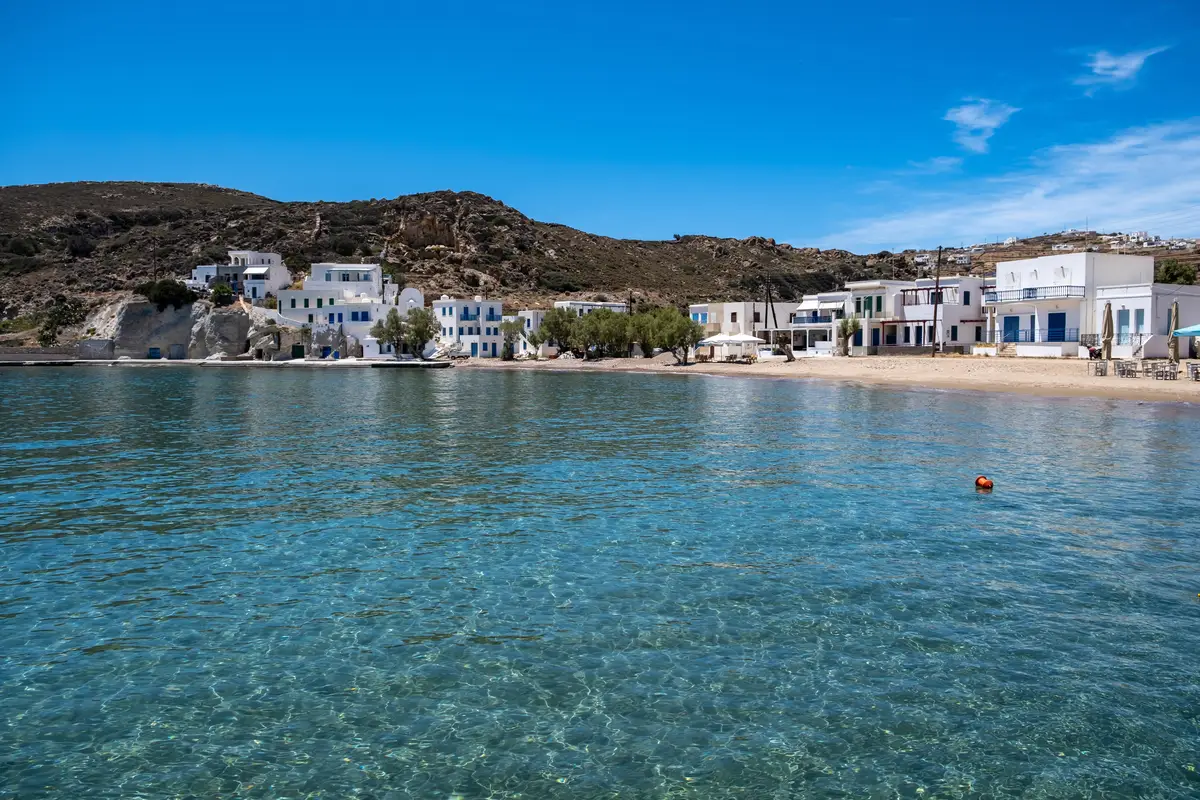 kimolos island psathi village cyclades greece whitewashed buildings sandy beach calm blue sea