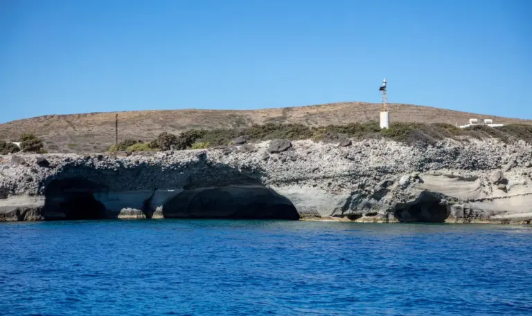 Σπήλαια 4 formaciones de roca volcánica cuevas mar en calma cielo azul isla de Kimolos Cícladas Grecia