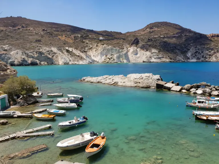 Scenic Milos bay with boats and cliffs